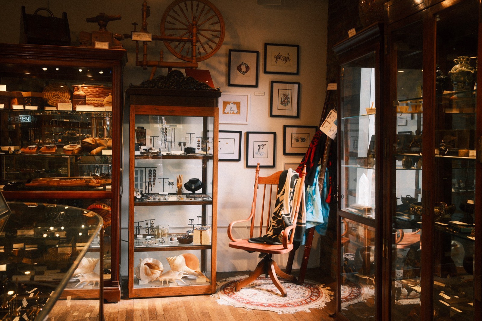 Antique display cabinets and framed artwork inside The Raven's Nest in Pike Place Market